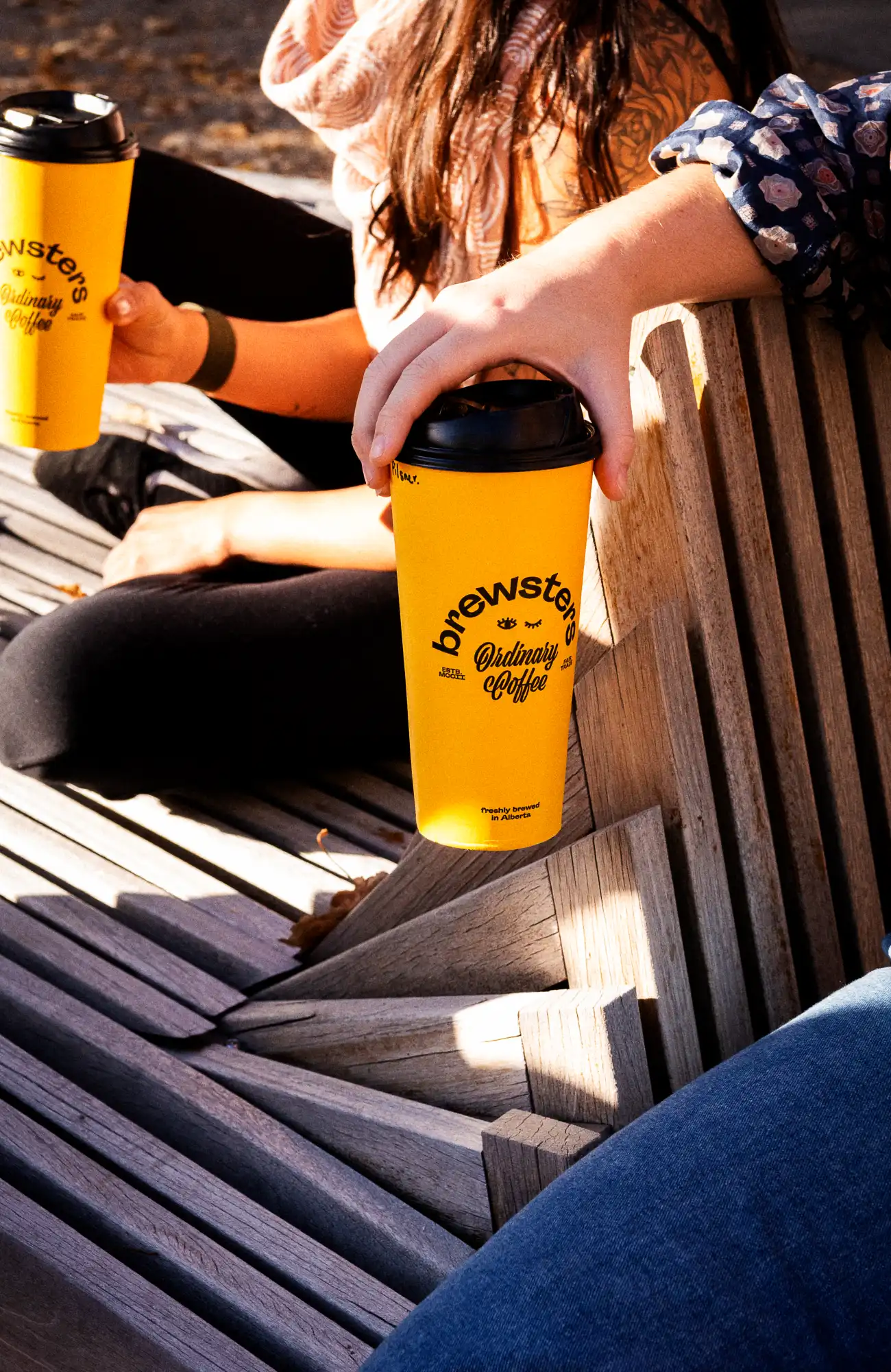 People holding Brewsters cups