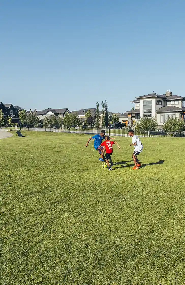 Kids playing soccer in a field