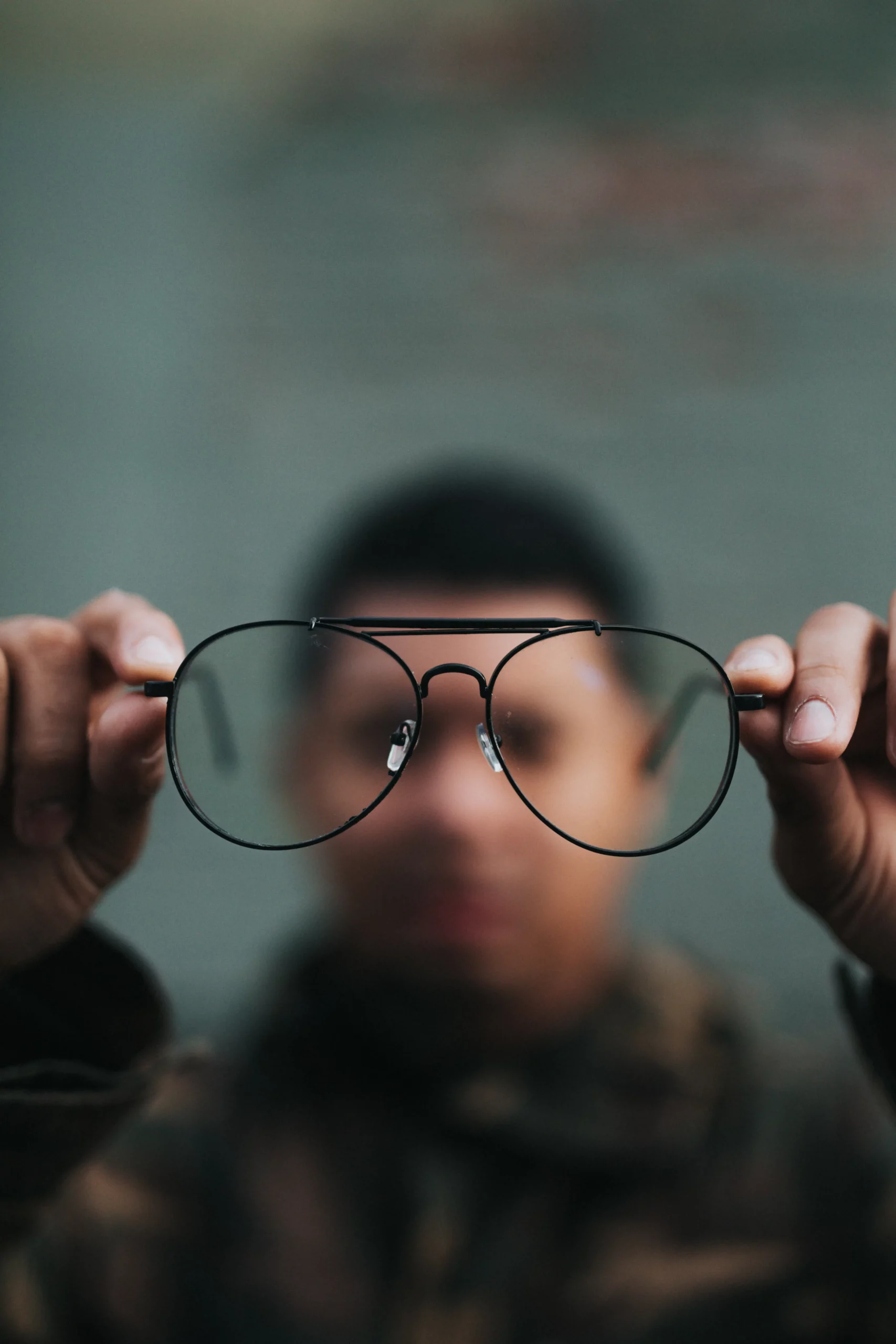 person holding up eye glasses